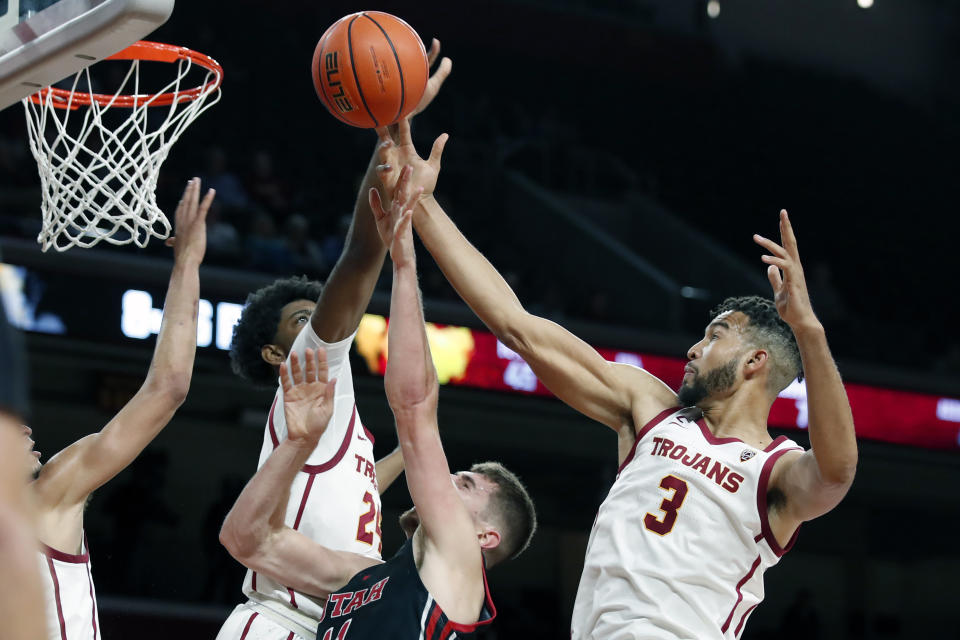 Southern California forward Joshua Morgan, left, and forward Isaiah Mobley, right, defend against a shot by Utah forward Riley Battin, center, during the first half of an NCAA college basketball game in Los Angeles, Wednesday, Dec. 1, 2021. (AP Photo/Alex Gallardo)