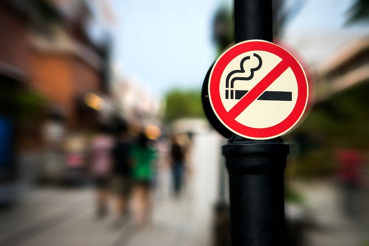 A no smoking sign hung on a post.