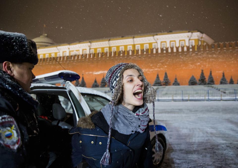 FILE - A police officer detains a gay rights activist in Red Square in Moscow, Russia, on Feb. 7, 2014. Police quickly detained LGBTQ+ activists who waved rainbow flags on Red Square, according to Russian news reports. Even before the Sochi Olympics, President Vladimir Putin had set the country on an increasingly repressive and isolationist course, intensifying a crackdown on opposition activists, stigmatizing civil society groups as "foreign agents," and approving laws that curtailed LGBTQ+ rights and banned adoption of Russian children by U.S. parents. (AP Photo/Evgeny Feldman, File)