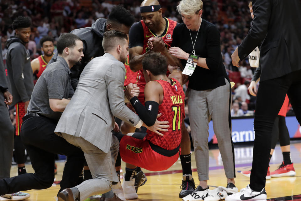 Atlanta Hawks guard Trae Young (11) is helped up off the court after an injury during the first half of the team's NBA basketball game against the Miami Heat, Tuesday, Oct. 29, 2019, in Miami. (AP Photo/Lynne Sladky)