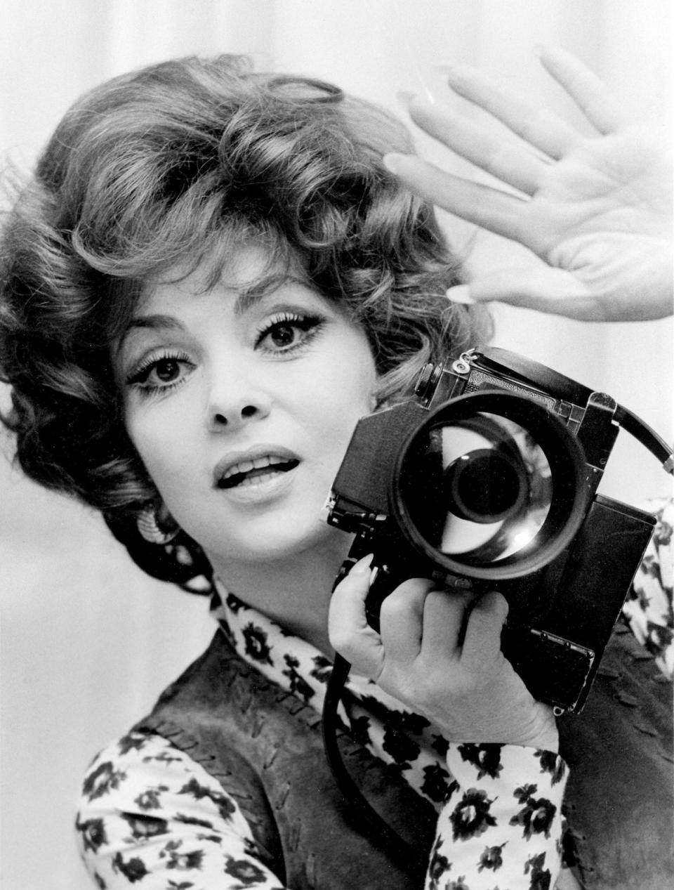 FILE - Portrait of Italian actress Gina Lollobrigida with one of her cameras photographed in her villa on the the Appian Way in Rome, Italy, November 26, 1972. Lollobrigida has died in Rome at age 95. Italian news agency Lapresse reported Lollobrigida’s death on Monday, Jan. 16, 2023 quoting Tuscany Gov. Eugenio Giani. (AP Photo/Massimo Sambucetti, File)