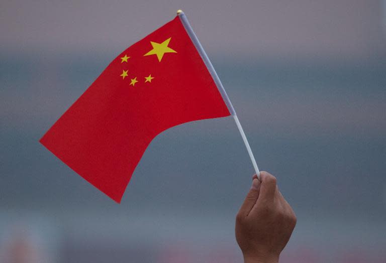 A man waves a Chinese flag in Tiananmen Square in Beijing early on June 3, 2012