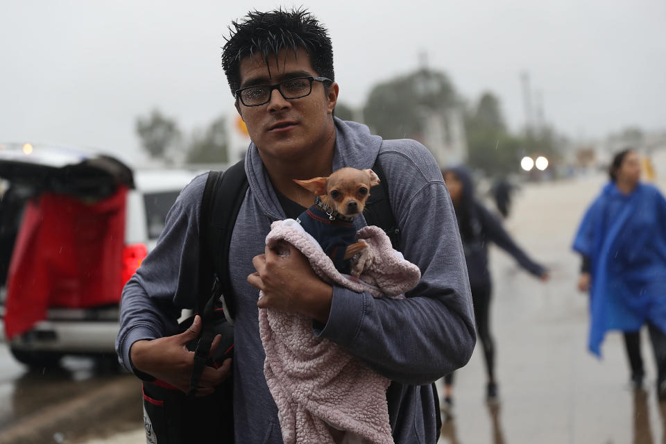 <p>Evacuees make their way to dry land after leaving their homes that were inundated with flooding from Hurricane Harvey on Aug. 28, 2017 in Houston, Texas. (Photo: Joe Raedle/Getty Images) </p>