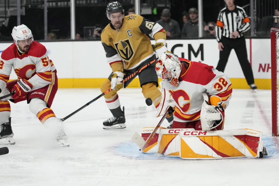 Calgary Flames goaltender Dustin Wolf (32) blocks a shot by the Vegas Golden Knights during the second period of an NHL hockey game Tuesday, Dec. 12, 2023, in Las Vegas. (AP Photo/John Locher)