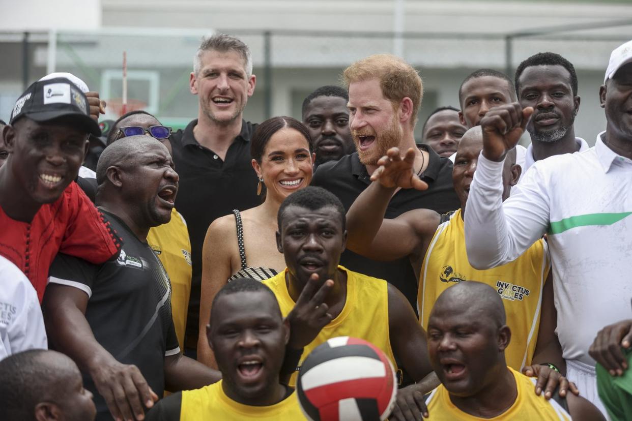 topshot britains prince harry cr, duke of sussex, and britains meghan cl, duchess of sussex, pose for a photographs with players ahead of an exhibition sitting volleyball match at nigeria unconquered, a local charity organisation that supports wounded, injured, or sick servicemembers, in abuja on may 11, 2024 as they visit nigeria as part of celebrations of invictus games anniversary photo by kola sulaimon afp photo by kola sulaimonafp via getty images