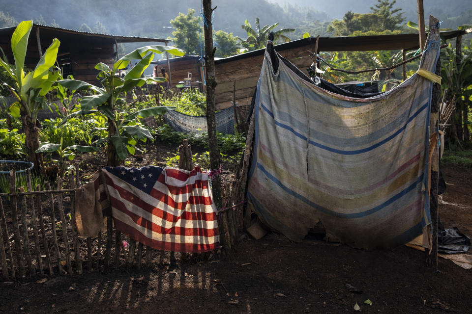 A U.S. flag that turned up among donations of second-hand clothing, is draped over a fence, near the outhouse of the Pop Chen family, in the makeshift settlement Nuevo Queja, Guatemala, Tuesday July 9, 2021. (AP Photo/Rodrigo Abd)