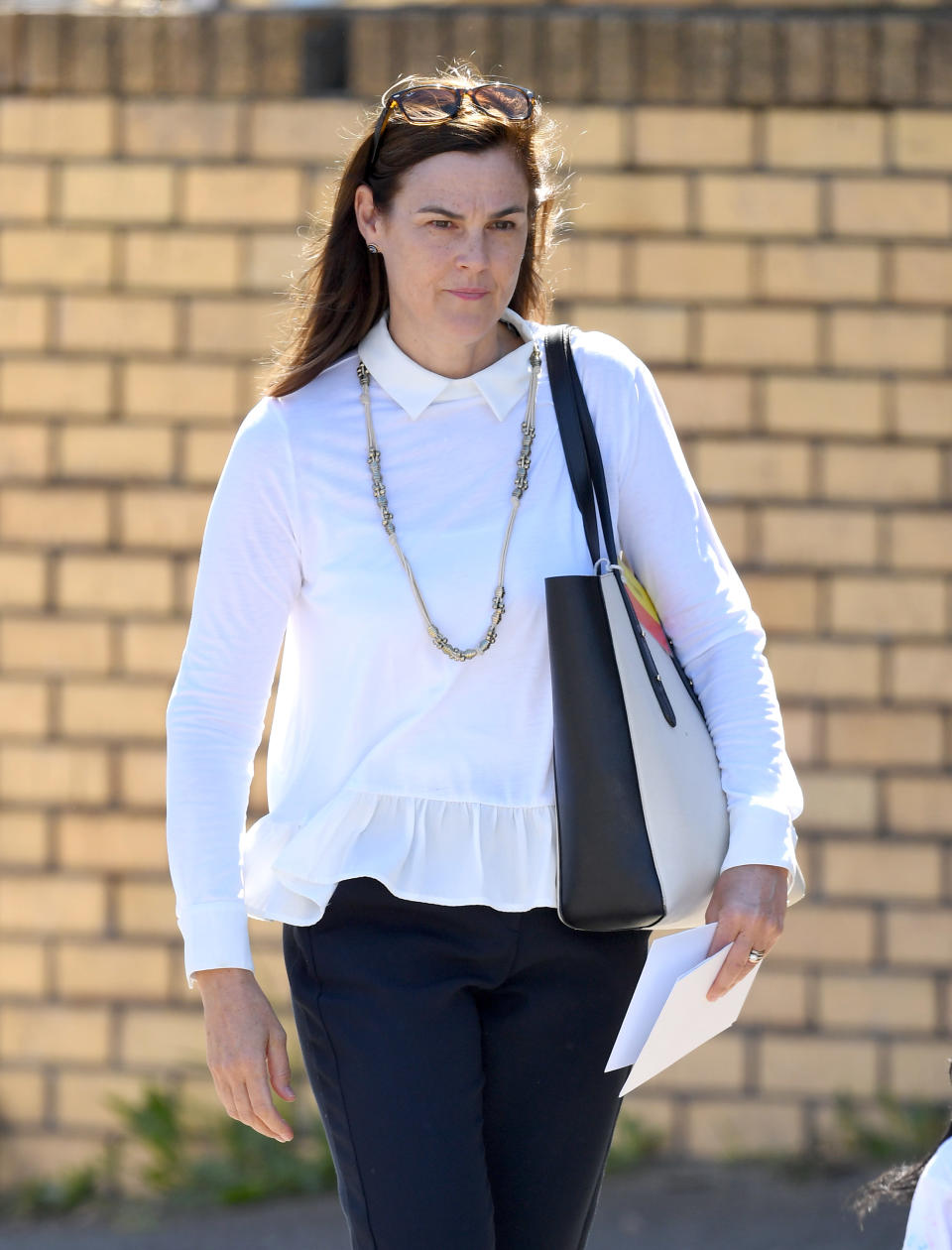 Samantha Cohen walking in a white top at Buckingham Palace