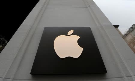 FILE PHOTO: The company's logo is seen outside Austria's first Apple store, which opens on February 24, during a media preview in Vienna, Austria, February 22, 2018. REUTERS/Heinz-Peter Bader