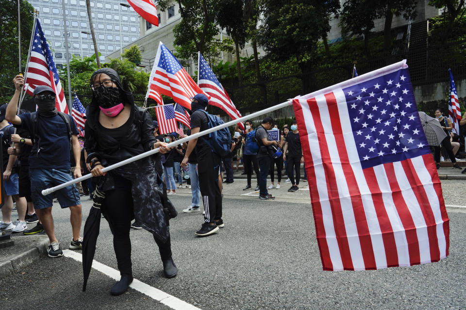 Protesters wave United States flags and during a protest in Hong Kong, Sunday, Sept. 8, 2019. Demonstrators in Hong Kong plan to march to the U.S. Consulate on Sunday to drum up international support for their protest movement, a day after attempts to disrupt transportation to the airport were thwarted by police. (AP Photo/Vincent Yu)