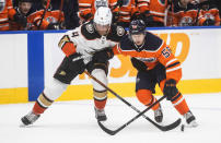 Anaheim Ducks' Cam Fowler (4) and Edmonton Oilers' Kailer Yamamoto (56) battle for the puck during the second period of an NHL hockey game Tuesday, Oct. 19, 2021, in Edmonton, Alberta. (Jason Franson/The Canadian Press via AP)