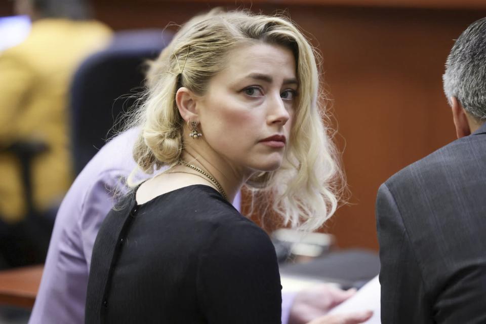 Amber Heard waits before the jury said that they believe she defamed ex-husband Johnny Depp, while announcing split verdicts in favor of both her ex-husband Johnny Depp and Heard