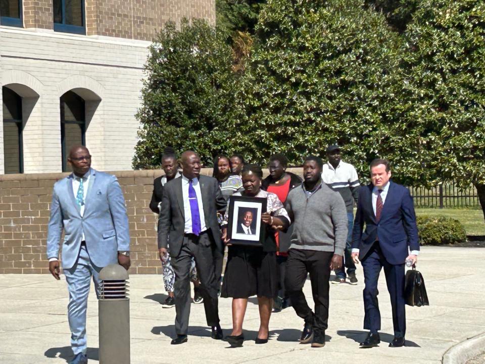 The mother and brother of Irvo Otieno ar joined by their attorneys and other family members as they walk to a news conference Thursday, March 16, 2023 in front of the Dinwiddie County Courthouse. Seven Henrico County deputies and three employees of Central State Hospital have been charged with second-degree murder in Otieno's death March 6 at the Dinwiddie County hospital.