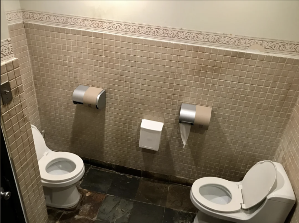 Public restroom with a toilet and an open baby changing station