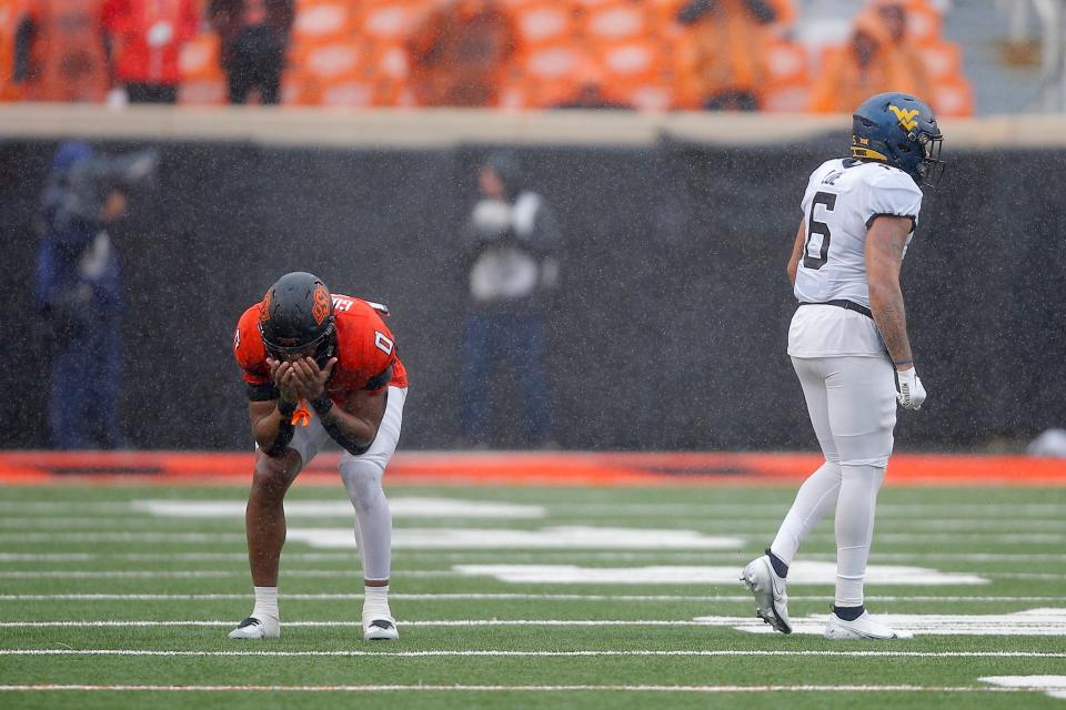 Oklahoma State Cowboys running back Ollie Gordon (0) reacts beside West Virginia Mountaineers linebacker Exree Loe (6) after Oklahoma State was stopped on thier last possession of a college football game between Oklahoma State and West Virginia at Boone Pickens Stadium in Stillwater, Okla., Saturday, Nov. 26, 2022. West Virginia won 24-19. 