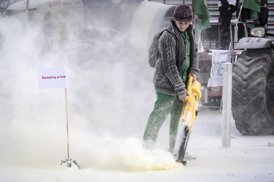 European dairy farmers spray the EU Council building with milk powder to protest the crisis in their sector, in Brussels on Monday, Jan. 23, 2017. The sector has been hit with sagging prices and production costs squeezing profits to the extent that has driven many farmers to the brink of bankruptcy. The EU's executive Commission has approved some support measures over the past year, but the farmers fear that releasing more milk powder on the market would further complicate their plight. (AP Photo/Geert Vanden Wijngaert)