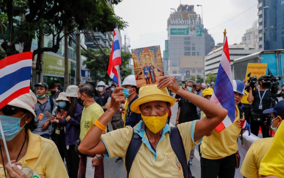 Supporters of the Thai monarchy came out wearing yellow and holding pictures of the king - AP Photo/Gemunu Amarasinghe