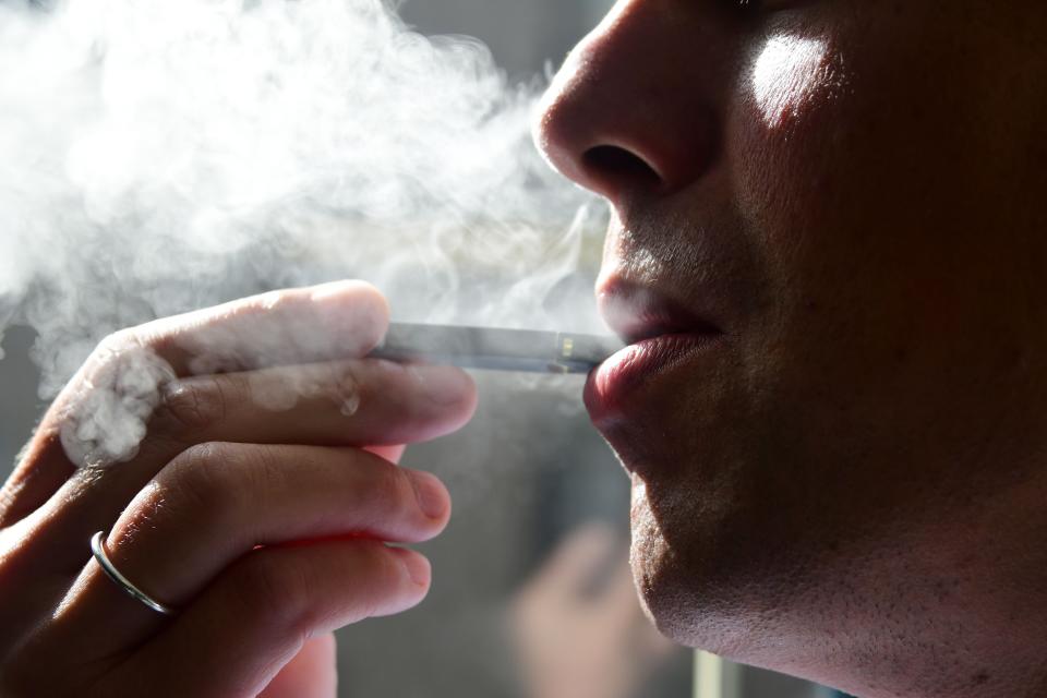 In this 2018 file photo, a man exhales smoke from an electronic cigarette in Washington, D.C.