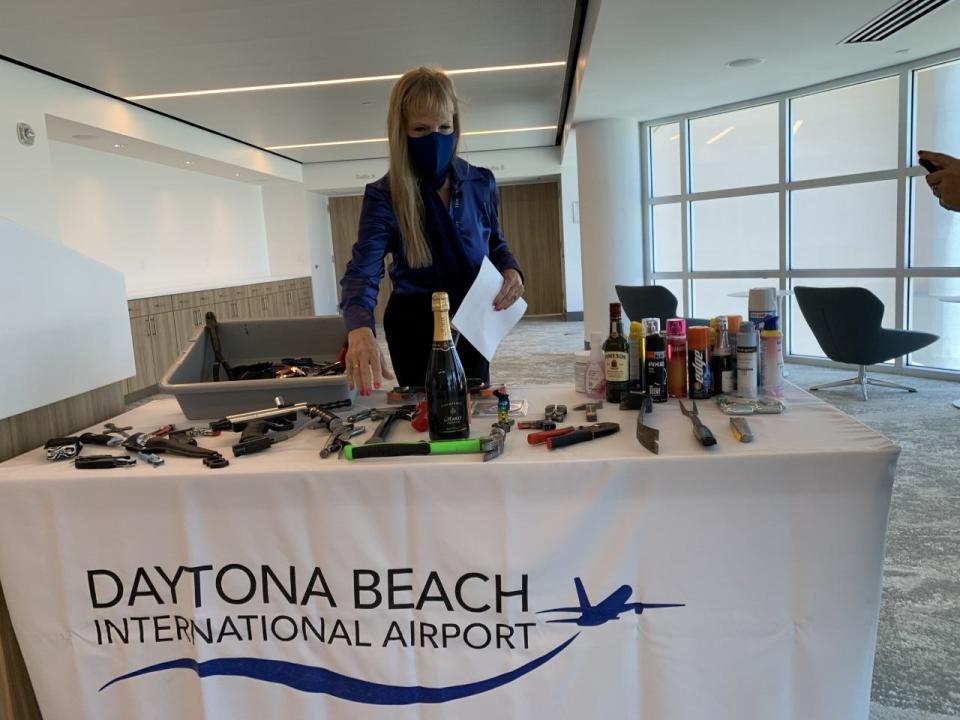 In this file photo from May, Sari Koshetz, a Transportation Security Administration spokeswoman, looks at a display of some of the items that TSA officials have had to take from departing air travelers at Daytona Beach International Airport. Guns confiscated from airports hit record numbers nationally and in Florida in 2021. Daytona Beach International Airport tied a previous record with six guns confiscated.