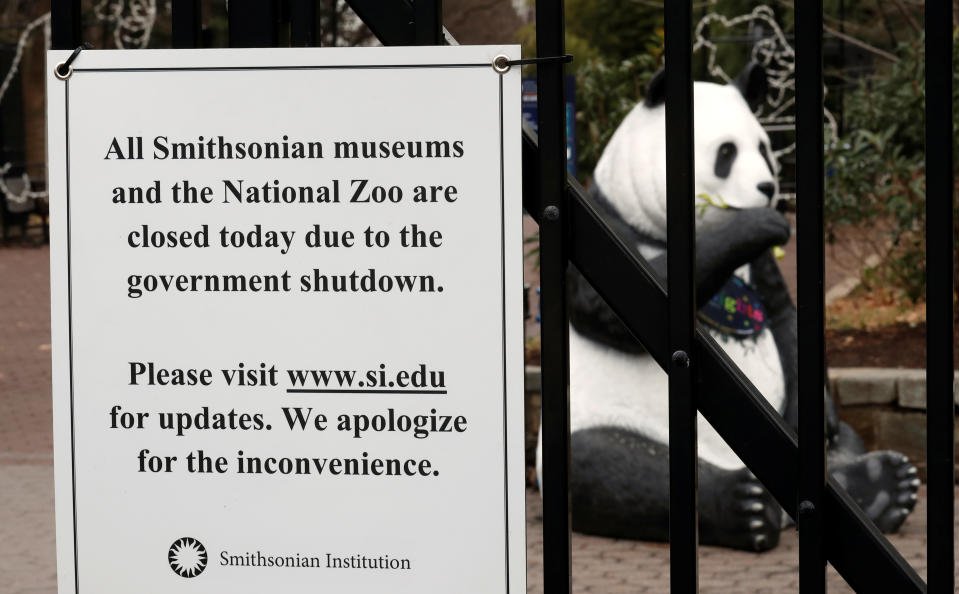 The figure of a panda is seen behind a sign telling the public that the National Zoo is closed due to the partial government shutdown in Washington, U.S., January 2, 2019. REUTERS/Kevin Lamarque - RC182C8B77D0