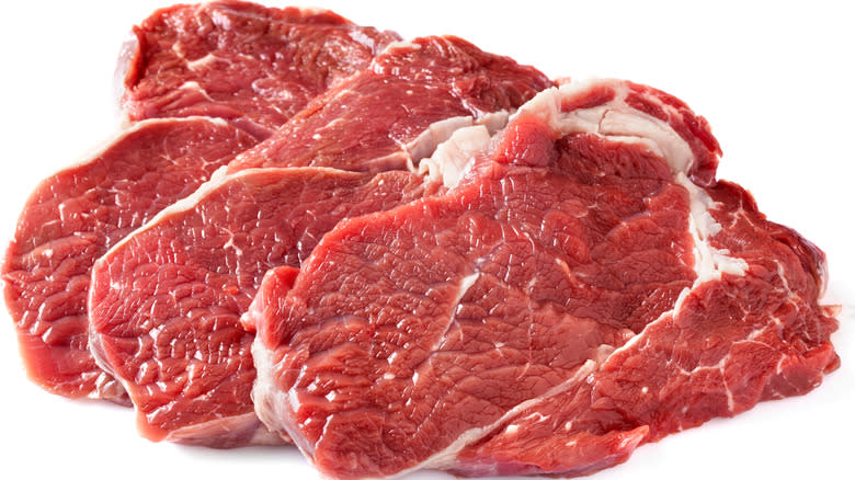 three raw chuck steaks