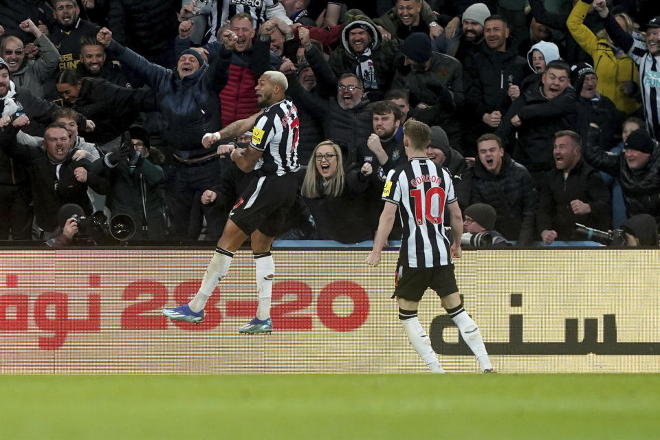 Newcastle United's Joelinton, left, celebrates after scoring his side's third goal of the game during the English Premier League soccer match between Newcastle United and Chelsea at St. James' Park, in Newcastle upon Tyne, England, Saturday, Nov. 25, 2023. (Owen Humphreys/PA via AP)