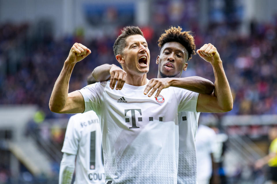 Bayern's Robert Lewandowski, front, celebrates scoring his side's third goal during the German Bundesliga soccer match between SC Paderborn 07 and FC Bayern Munich in Paderborn, Germany, Saturday, Sept. 28, 2019. (David Inderlied/dpa via AP)