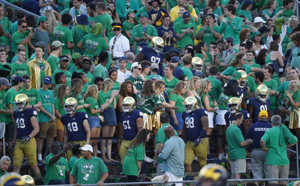 Notre Dame players enter the stadium through the crowd before an NCAA football game against Michigan in South Bend, Ind., Saturday, Sept. 1, 2018. (AP Photo/Paul Sancya)