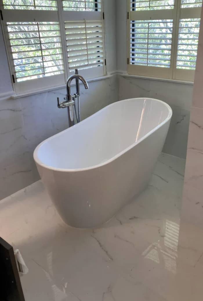 Bathroom with a freestanding bathtub near a window, with title "Yet another freestanding tub install."