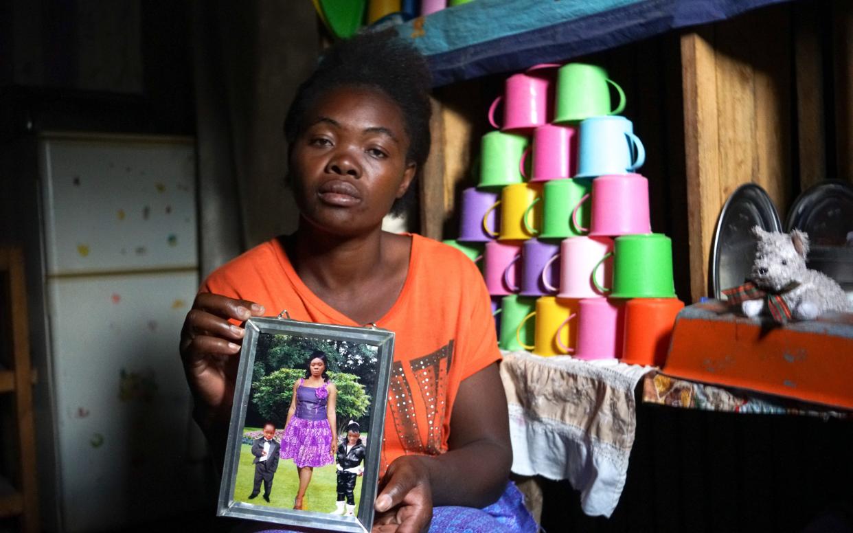 Mother-of-four Mirriam holds a picture her five-year-old daughter Jennifer (right, in image) taken two days before she died of cholera - Chileshe Chanda/WaterAid