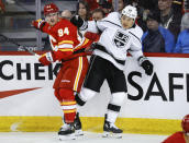 Los Angeles Kings forward Trevor Moore (12) checks Calgary Flames defenseman Brayden Pachal (94) during the first period of an NHL hockey game Saturday, March 30, 2024, in Calgary, Alberta. (Jeff McIntosh/The Canadian Press via AP)