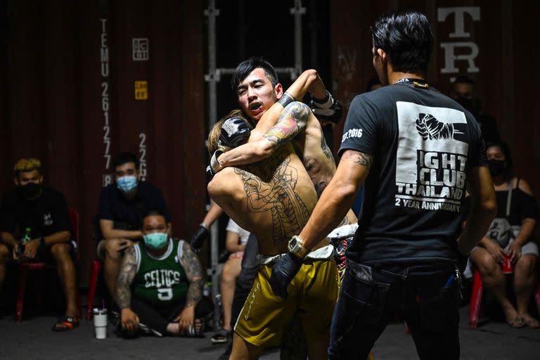 Combatientes pelean en un evento del Fight Club Thailand, una organización clandestina que planifica peleas no autorizadas de varias disciplinas de artes marciales, en un estacionamiento en el distrito Klong Toey de Bangkok