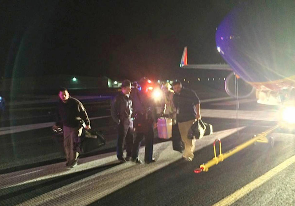 In this Sunday, Jan. 12, 2014 photo provided by Scott Schieffer, passengers exit a Southwest Airlines flight that was supposed to land at Branson Airport in Branson, Mo., but instead landed at Taney County Airport, in Hollister, Mo., that only has about half as much runway. A Southwest spokesman said all 124 passengers and five crew members were safe. (AP Photo/ Scott Schieffer) MANDATORY CREDIT