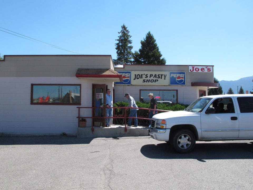This July 20, 2013 photo shows customers entering Joe's Pasty Shop in Butte, Mont. The shop is one of a handful that serve the meat-and-potato pie that immigrant miners brought a century ago and has remained a part of Butte's culinary culture. (AP Photo/Matt Volz)