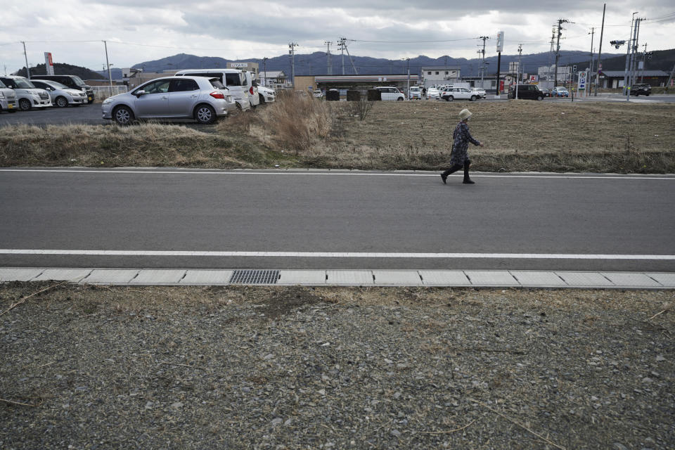 A woman walks through the city of Minamisanriku, Miyagi Prefecture, northern Japan, Saturday, March 6, 2021, nearly ten years after the Tsunami. (AP Photo/Eugene Hoshiko)