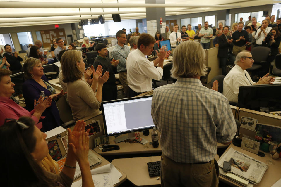 BOSTON - APRIL 14: Editor Brian McGrory, center, and members of the newsroom applaud after The Boston Globe was awarded a Pulitzer prize for Breaking News for their coverage of the Boston Marathon bombings, April 14, 2014. (Photo by Jessica Rinaldi for The Boston Globe via Getty Images)