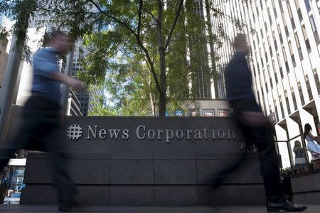 Passers-by walk near the News Corporation building in New York June 28, 2012. REUTERS/Keith Bedford/File Photo