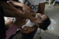 Una niña es inoculada contra el polio durante una campaña de vacunaciones del gobierno en Caracas el 18 de junio del 2022. (AP Photo/Ariana Cubillos)