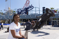 Ayo Robinson, the granddaughter of baseball great Jackie Robinson, pauses next to a sculpture of her grandfather on Jackie Robinson Day before a baseball game between the Los Angeles Dodgers and the Washington Nationals at Dodgers Stadium in Los Angeles, Monday, April 15, 2024. (AP Photo/Damian Dovarganes)