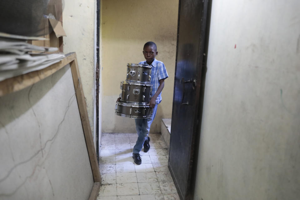 Woodberson Seide puts his drums away after a practice session at the Plezi Mizik Composition Futures School in Port-au-Prince, Haiti, Thursday, Sept. 21, 2023. Woodberson Seide took his first lesson two years ago as part of the after-school music program founded in 2014 by U.S. nonprofit Music Heals International. (AP Photo/Odelyn Joseph)