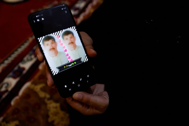 Ikhlas Talal, 43, shows a picture of her husband, who went missing as their area was liberated from Islamic State in 2016, in Saqlawiya