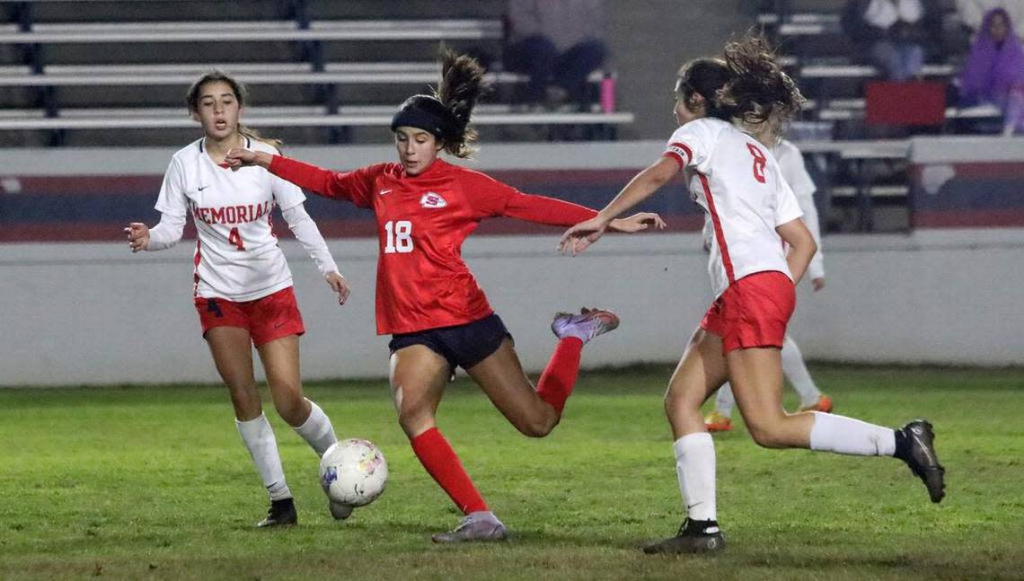 Royce Kilby of Sanger takes a shot against the defense of Ella Saroyan and Bella Hernández of San Joaquín Memorial during a Jan. 27, 2023 CMAC match at Tom Flores Stadium. Sanger won, 4-2, to improve to 5-0-1 in league play.