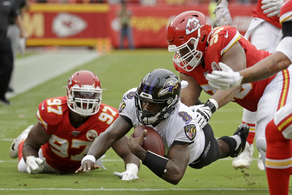 Baltimore Ravens quarterback Lamar Jackson (8) is tackled by Kansas City Chiefs defensive end Alex Okafor (97) and defensive tackle Xavier Williams, right, during the first half of an NFL football game in Kansas City, Mo., Sunday, Sept. 22, 2019. (AP Photo/Charlie Riedel)