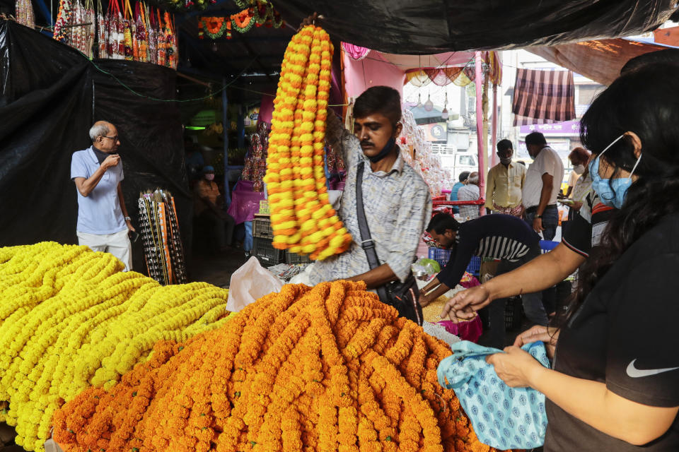 A roadside vendor displays garlands of marigold flowers, popularly used as offering to Hindu deities, during Diwali, the Hindu festival of lights, in Kolkata, India, Thursday, Nov. 4, 2021. Millions of people across Asia are celebrating the Hindu festival of Diwali, which symbolizes new beginnings and the triumph of good over evil and light over darkness. (AP Photo/Bikas Das)