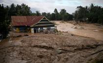 A house is seen submerged in mud after flash floods swept through a Radda Village, as several people were killed and dozens remain missing, in North Luwu in Sulawesi