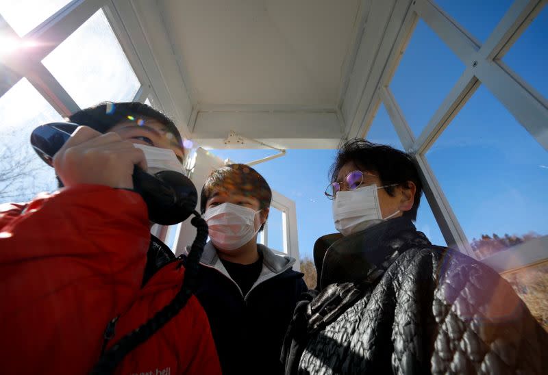 The Wider Image: Japan's tsunami survivors call lost loves on the phone of the wind