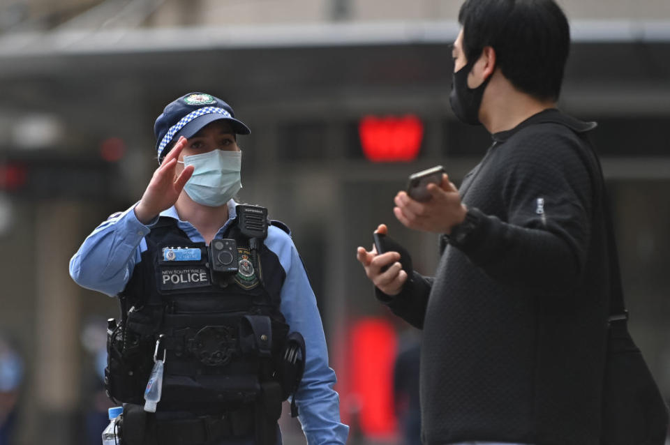 Police officers check ID cards of people walking in the CBD in order to prevent an anti-lockdown protest, during lockdown in Sydney, Australia, Saturday.