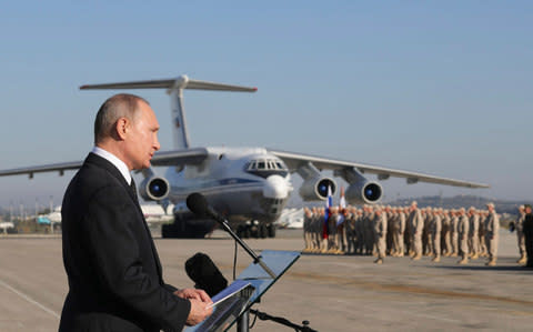 Russian President Putin addresses servicemen as he visits the Hmeymim air base in Latakia Province - Credit: Reuters