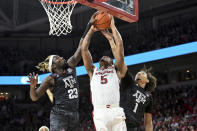 Arkansas guard Au'Diese Toney (5) has his shot blocked as he tries to drive past Texas A&M defenders Tyrece Radford (23) and Marcus Williams (1) during the first half of an NCAA college basketball game Saturday, Jan. 22, 2022, in Fayetteville, Ark. (AP Photo/Michael Woods)