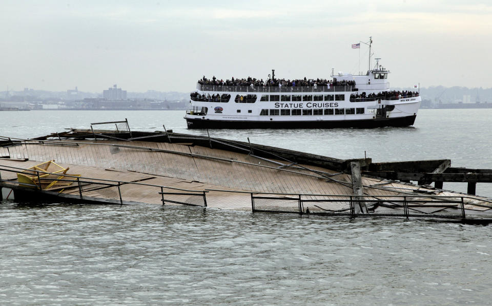 A Statue Cruises tour boat passes the damaged auxiliary pier on Liberty Island, in New York, Friday, Nov. 30, 2012. Tourists in New York will miss out for a while on one of the hallmarks of a visit to New York, seeing the Statue of Liberty up close. Though the statue itself survived Superstorm Sandy intact, damage to buildings and Liberty Island's power and heating systems means the island will remain closed for now, and authorities don't have an estimate on when it will reopen. (AP Photo/Richard Drew)