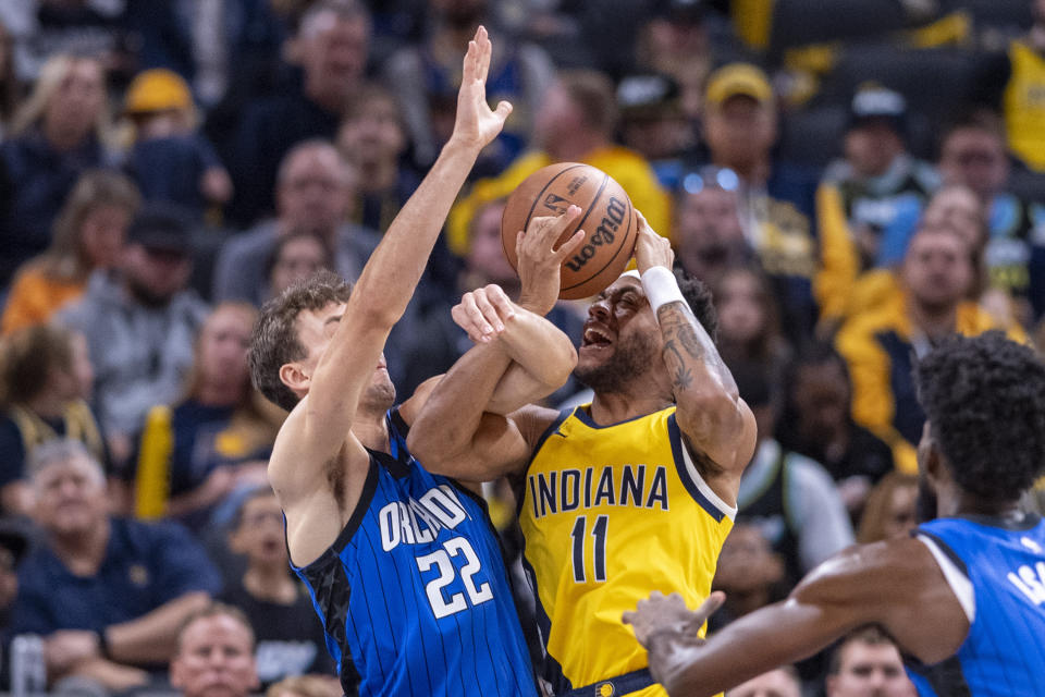 Orlando Magic forward Franz Wagner (22) and Indiana Pacers forward Bruce Brown (11) tangle as Brown attempts to shoot during the first half of an NBA basketball game in Indianapolis, Sunday, Nov. 19, 2023. (AP Photo/Doug McSchooler)